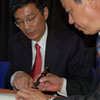 Dr Junqi Yan (left) and Jin Shudong signing the agreement