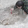 Excavation of a skeleton and a pot in a storage pit