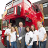 Vice Chancellor John Vinney with students outside the Coca Cola Olympic bus
